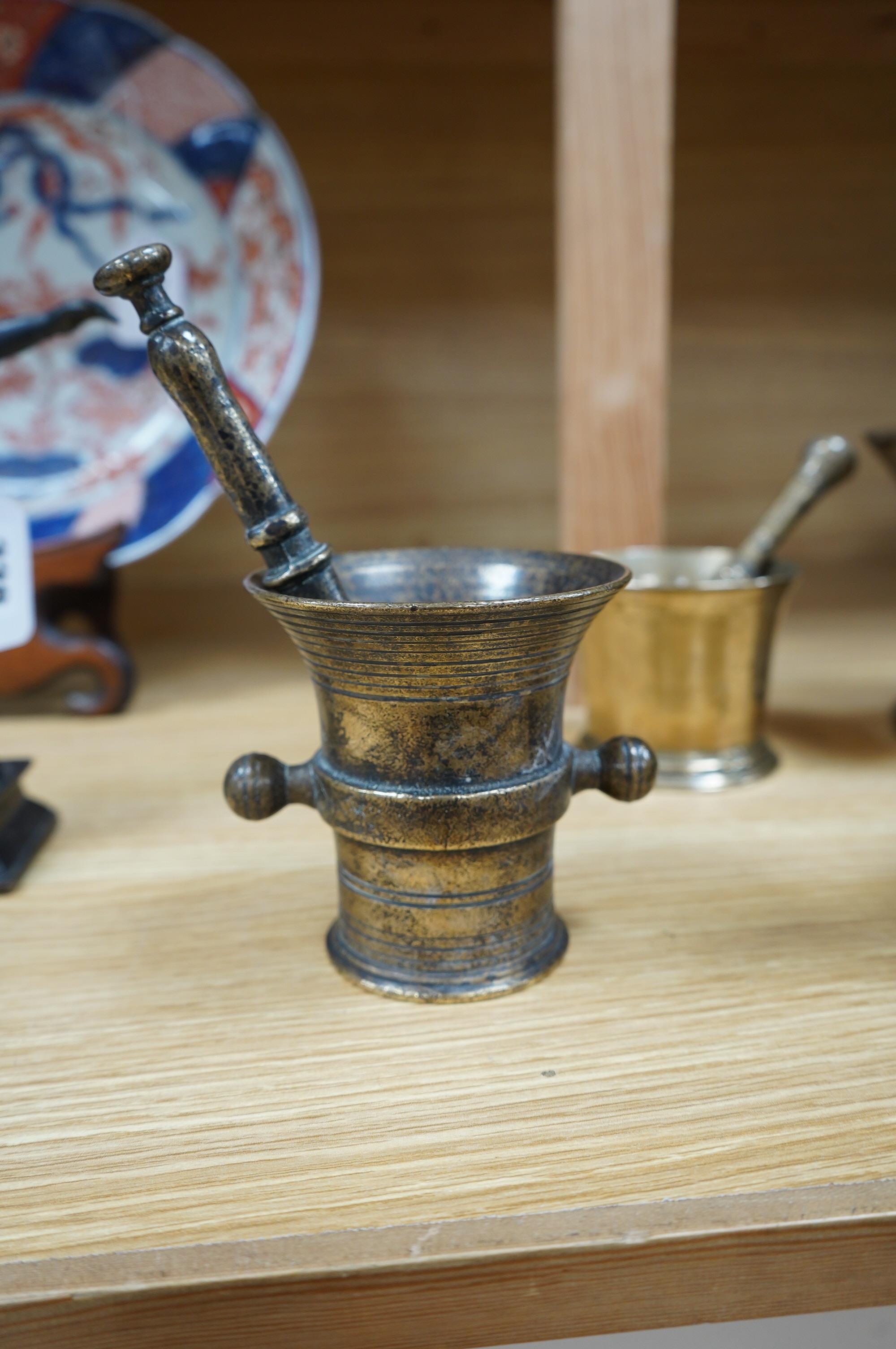 Four various bronze pestles and mortars and a small enamelled brass photograph frame, largest mortar 13cm high. Condition - fair